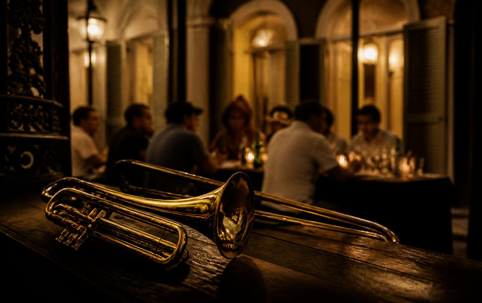 Brass instruments resting near a candlelit communal table